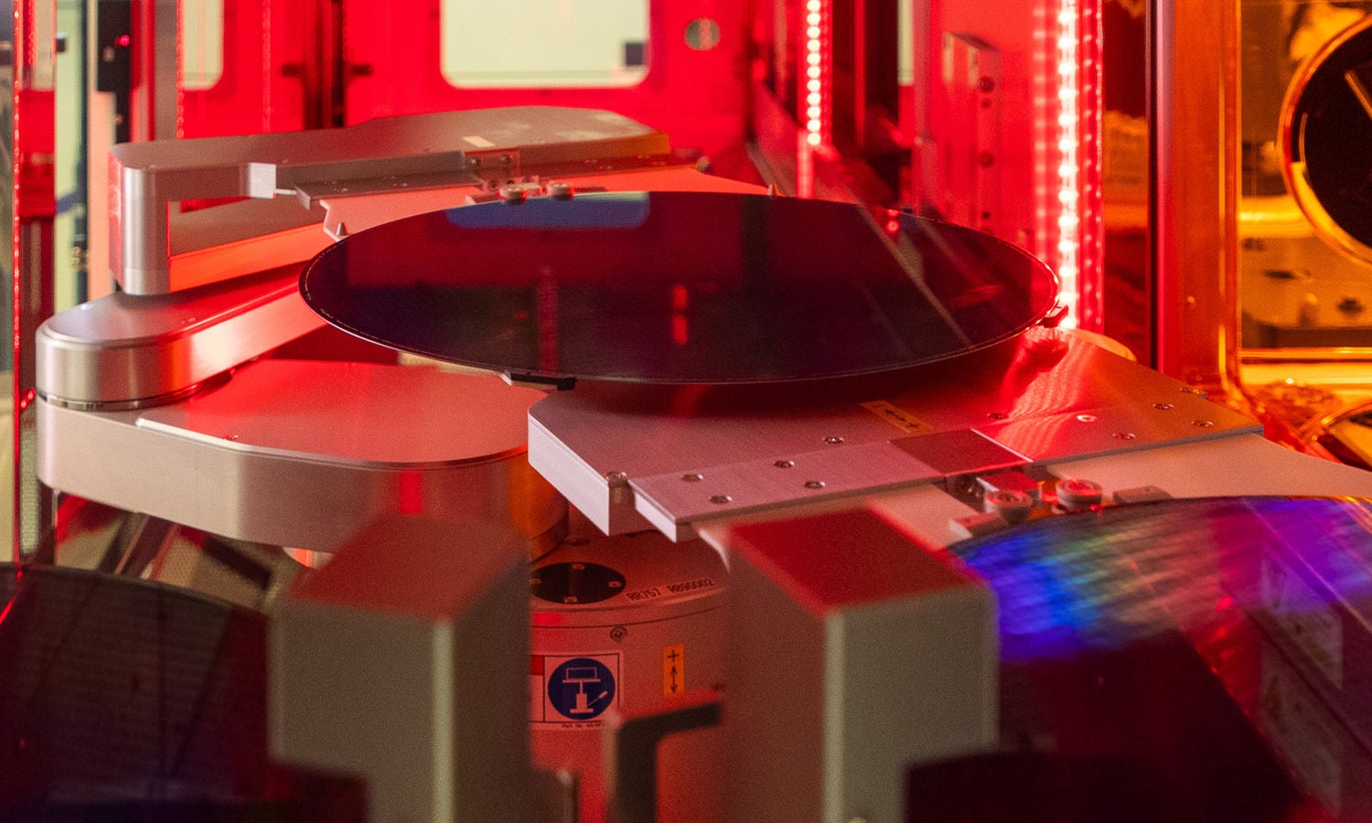 Silicon wafer on robotic arm in red light
