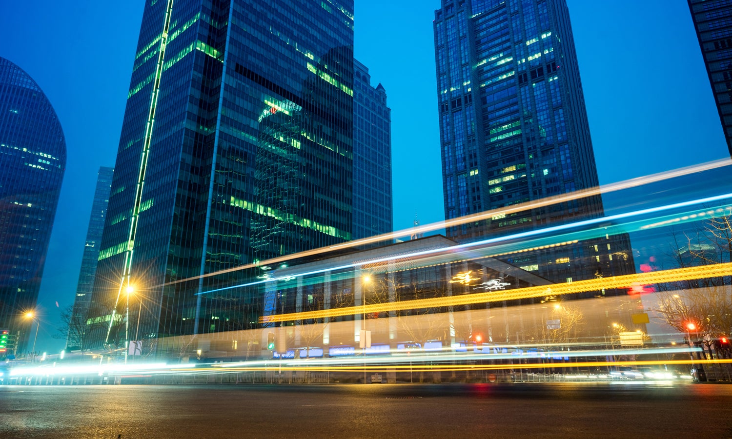 City skyline at dusk with a time-lapse traffic blur